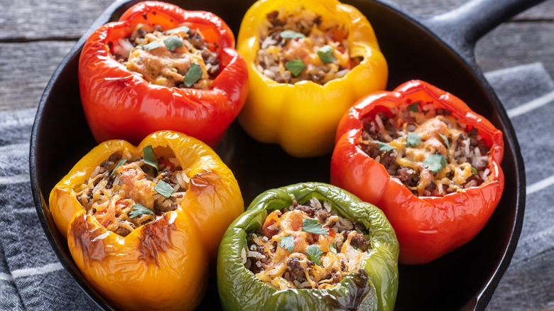 Stuffed bell peppers (yellow and red) on a black plate