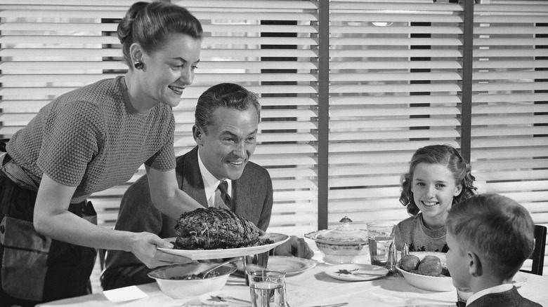 A vintage photo of a family eating at the dinner table