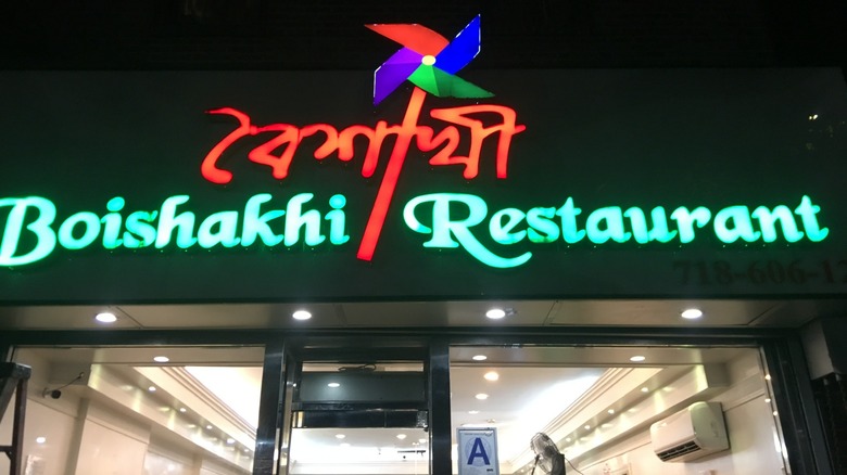Neon sign for Boichakhi Restaurant above the door at night
