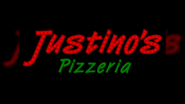 Justino's Pizzeria neon logo on black