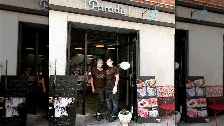 Two people standing at the door of Paradis To Go