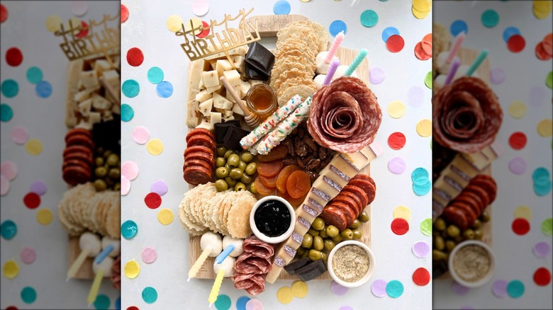 Birthday-themed charcuterie assortment with meats, cheeses, and other foods.