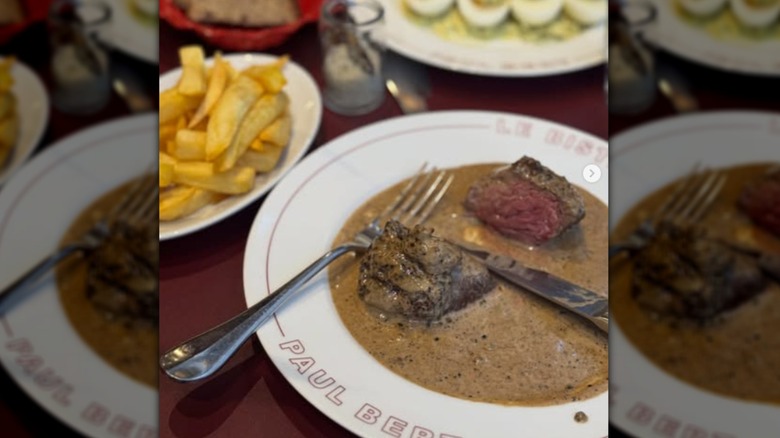 steak au poivre on a white plate with a side of French fries