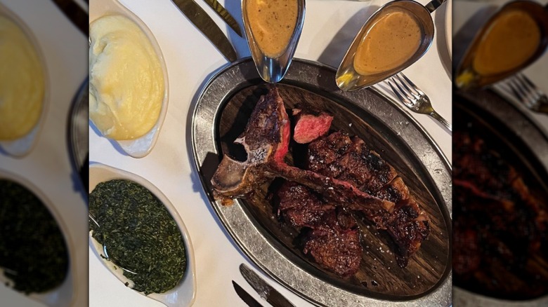 steak serve with sauce, mashed potatoes, and creamed spinach shot from above on a white tablecloth