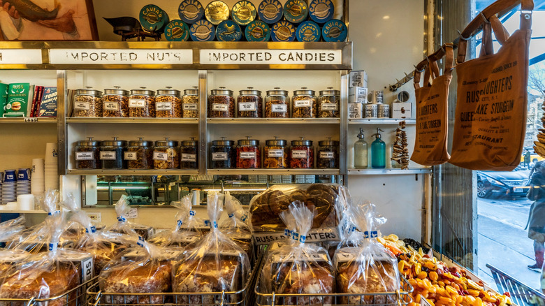 Photograph of a deli counter in New York with canisters of nuts and berries and bags of bread