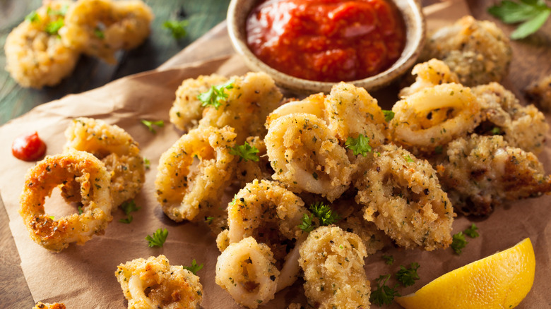 fried calamari rings with side of cocktail dipping sauce and lemon wedge