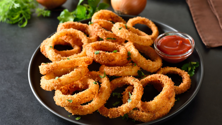 onion rings on plate with red sauce on side