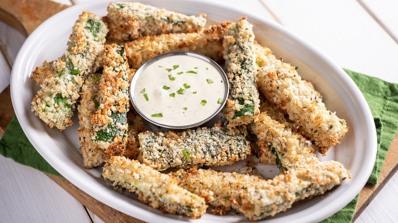 zucchini fries in serving bowl with creamy dipping sauce