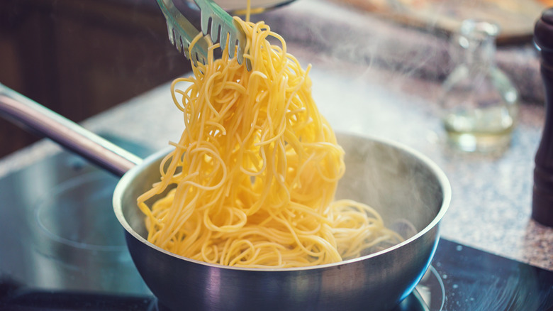 Spaghetti cooking in pan