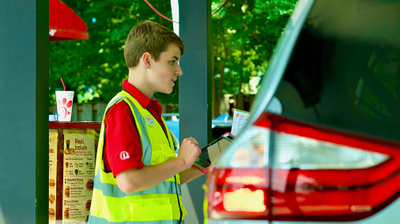 A Chick-fil-A employee taking a drive-thru order