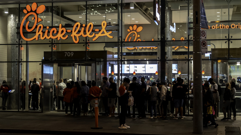 A Chick-fil-A with big crowds at night