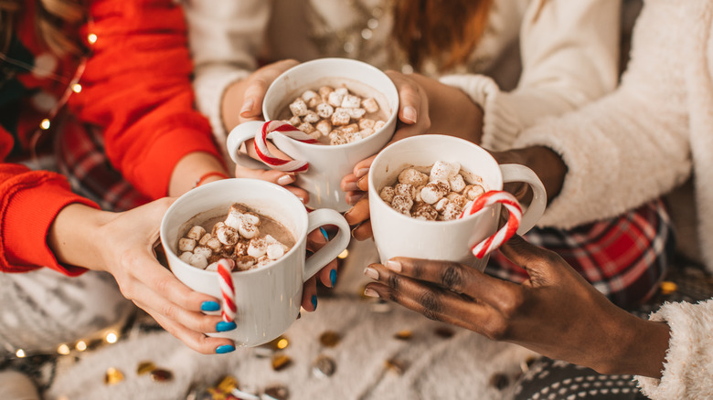 People holding festive hot chocolate mugs