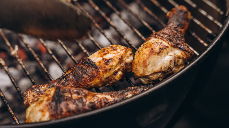 Three chicken drumsticks on grill