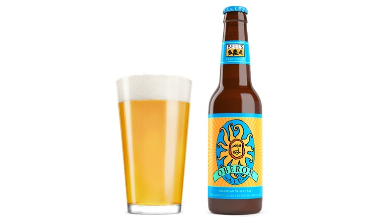 pint glass of beer next to a bottle of Oberon Ale on a white background