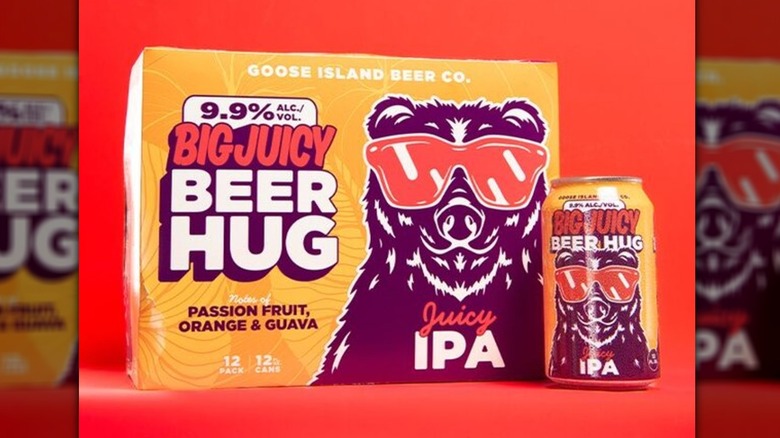 Orange box of Goose Island Big Juicy Beer Hug IPA beer next to an individual can with a bright red backdrop