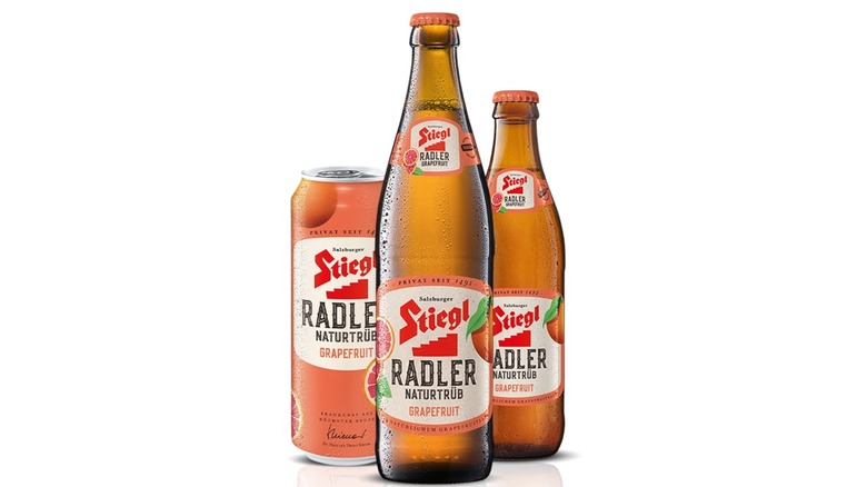 Can and two bottles of grapefruit radler on a white background