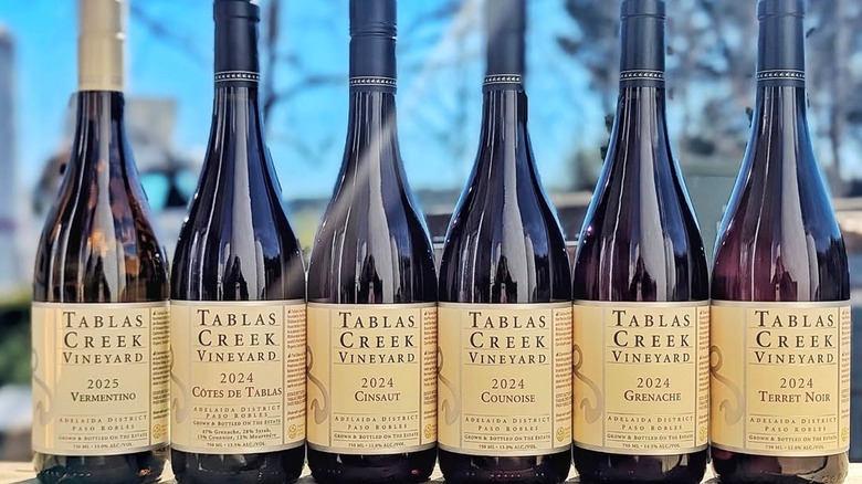 Bottles of Tablas Creek red wines lined up on wooden pallet outdoors