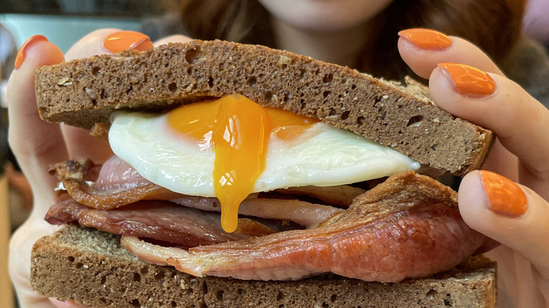 Closeup of fried egg and bacon sandwich