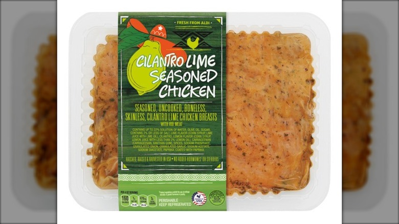 Plastic container of cilantro lime seasoned chicken against white background.