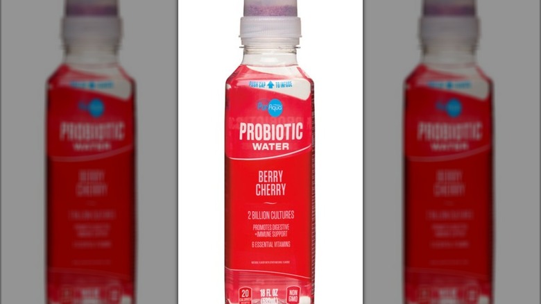 Bottle of berry cherry-flavored probiotic water against white background.