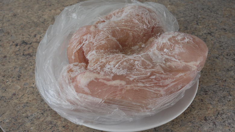 Frozen chicken breasts thawing on a plate on the counter