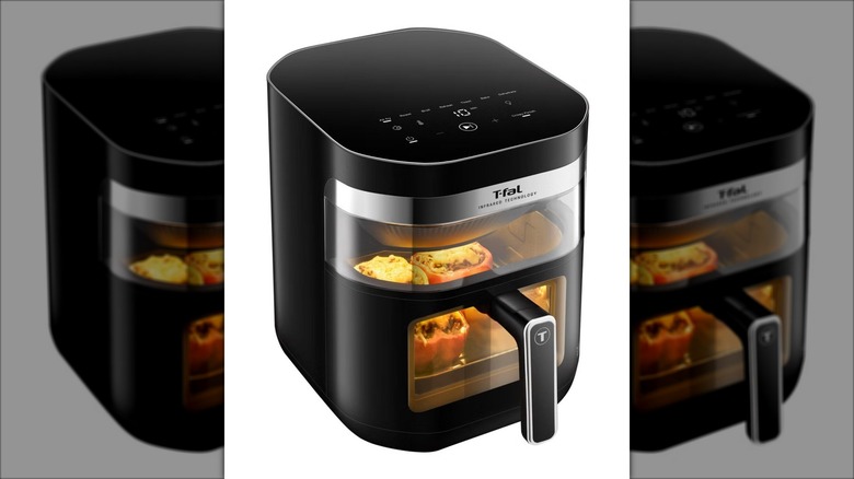 Infrared air fryer with stuffed peppers cooking inside.