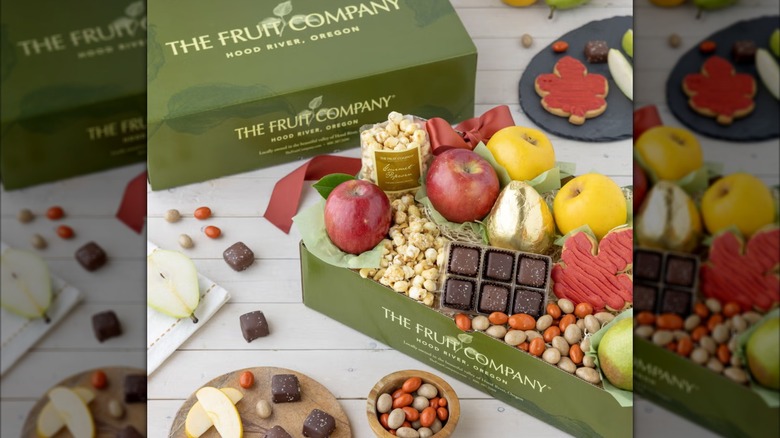 Gift box with fruit, chocolates, popcorn, and other snacks.