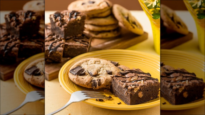 A plate with a cookie, brownie, and fork, with more cookies and brownies in the background.