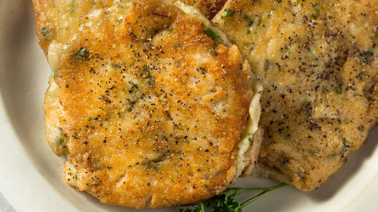 Small, circular potato cakes on plate seasoned with spices