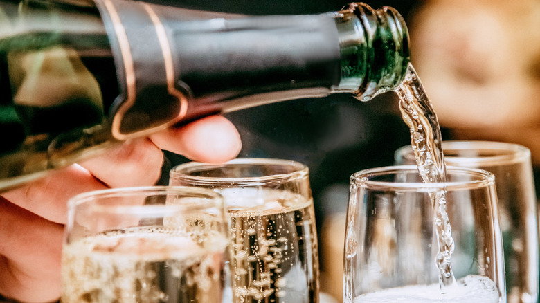 Pouring champagne into several glasses