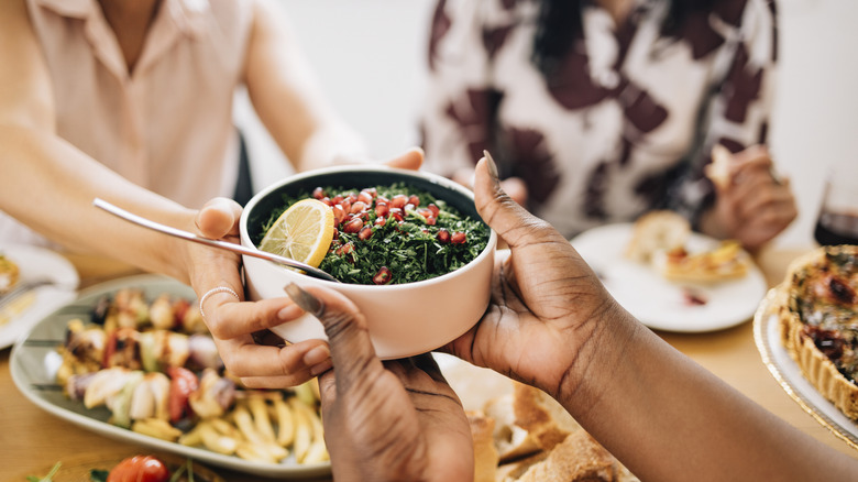 A family passing a plate of food to each other