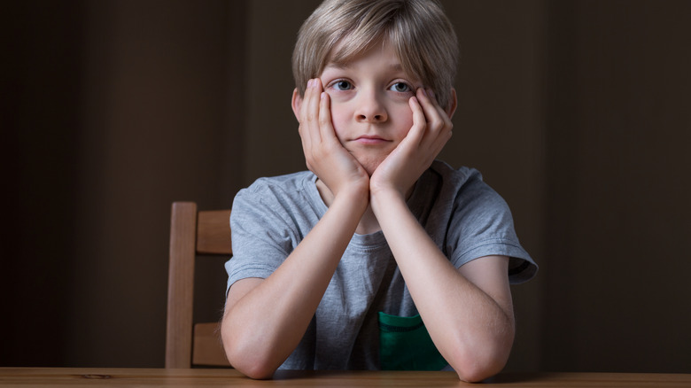 A boy sitting with his elbows on the table