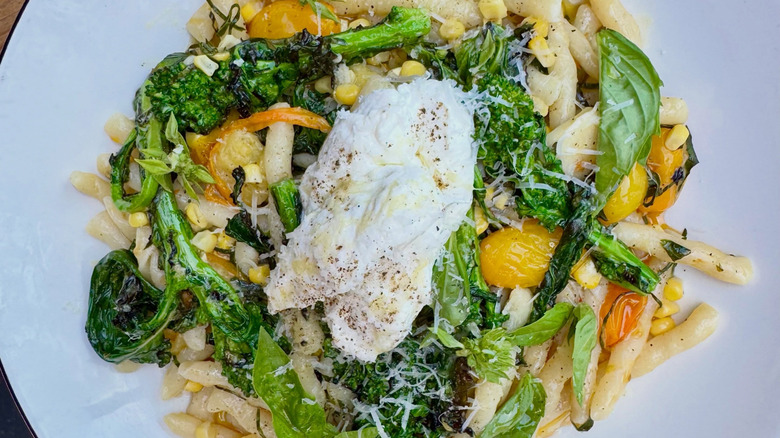 Pasta with vegetables on a white plate at Playa Provisions