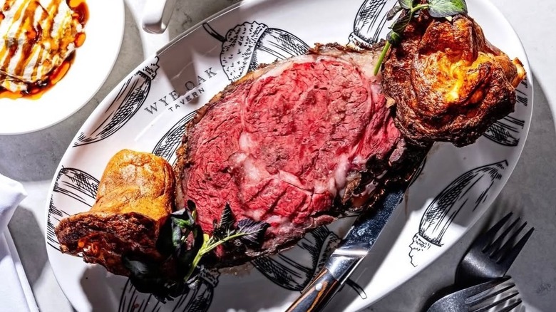 Prime rib dinner with cheddar popover on a decorative white platter at Wye Oak Tavern
