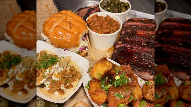 Variety of BBQ foods from Mabel's, including ribs, pulled pork sandwich, baked beans, and collard greens