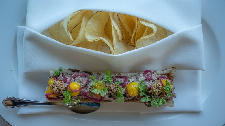 Bone marrow dish with chips tucked into a white napkin at Miller and Lux