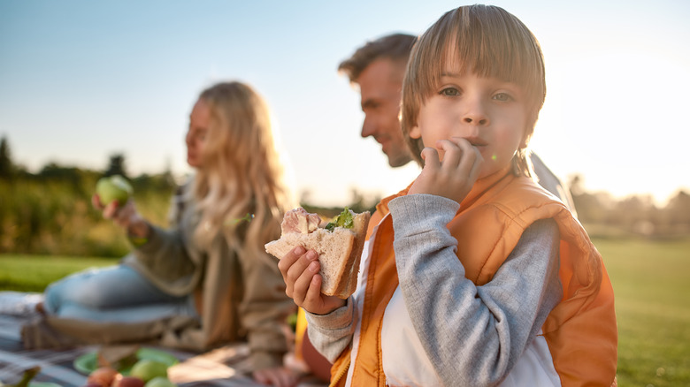 boy sandwich man woman picnic