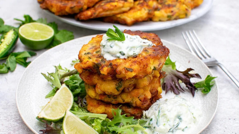 Stack of corn and jalapeno fritters with fresh lime