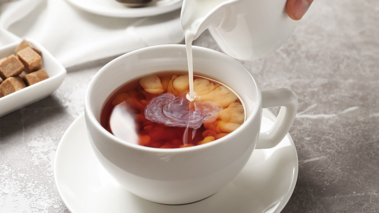 pouring milk into tea