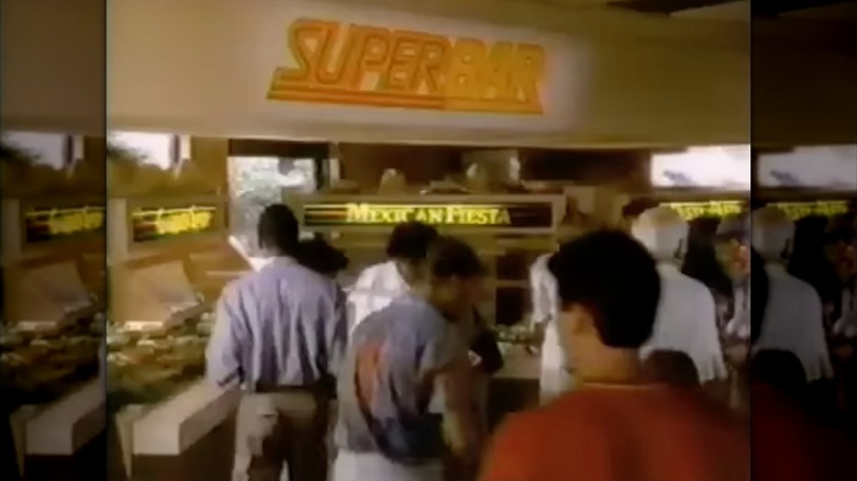 Screenshot from '80s commercial with customers lining up at Super Bar, a hot food and salad buffet at Wendy's