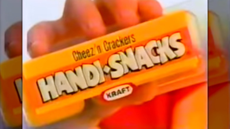 Screenshot from '80s commercial of hand holding Kraft Cheez n Crackers handi snacks