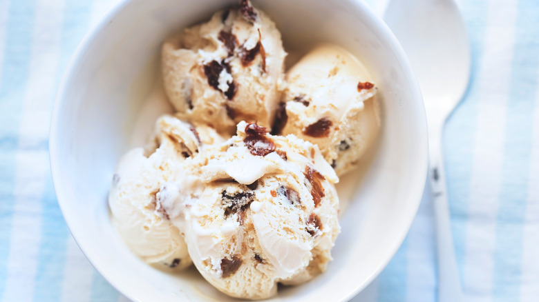 Rum raisin ice cream scoops in a white bowl