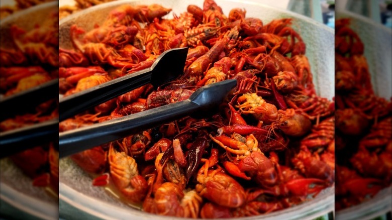 A platter of crawfish with tongs