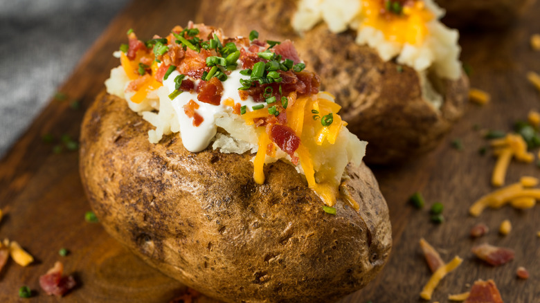 Loaded baked potato on a wooden board