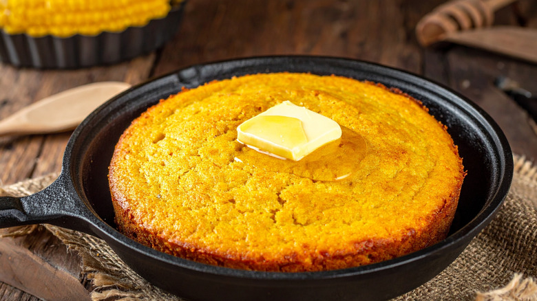 Cornbread in a cast-iron pan with melting butter on top