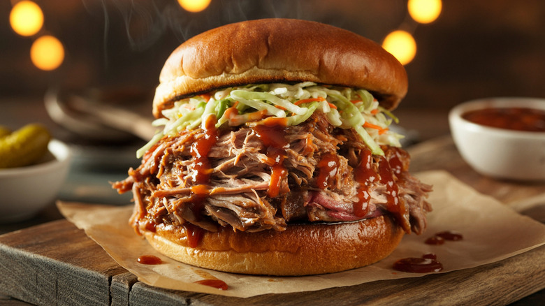 A pulled pork sandwich on a wooden board