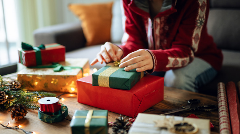 person wrapping christmas gifts