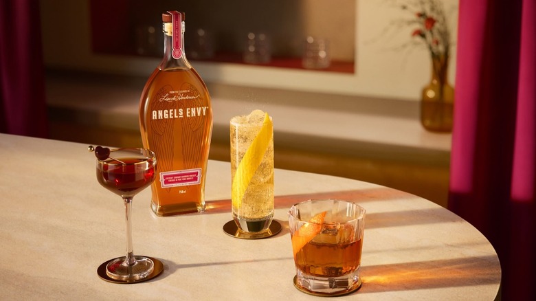 Bottle of Angel's Envy with assorted cocktails on table