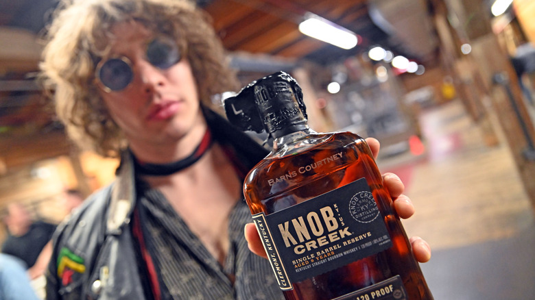 Barnes Courtney holding a bottle of Knob Creek