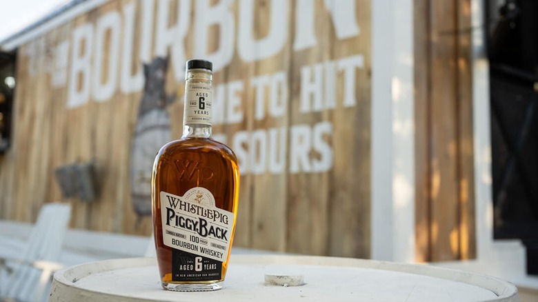 WhistlePig PiggyBack 6-Year on barrel outside wooden building